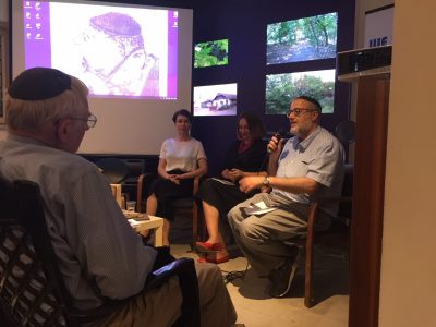 Ukrainian writer Sofia Andrukhovych (left); Mariana Maksymiak, Director of the Agnon Literary Center (middle); and Rabbi Jeffrey Saks, Research Director at the Agnon House (right) at the Jerusalem presentation of “The Key in the Pocket”.  A portrait of Buchach-born, Nobel-prize winning writer S.Y. Agnon is displayed on the screen in the background.