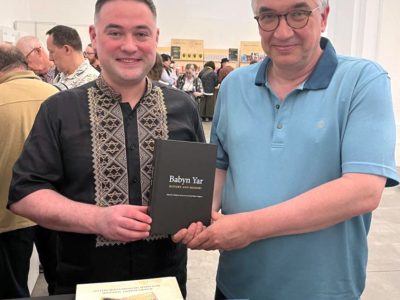 Vladyslav Hrynevych, Jr., Regional Manager of UJE in Ukraine, presents the book "Babyn Yar: History and Memory" to Roman Waschuk, diplomat, former Ambassador of Canada to Ukraine, Business Ombudsman of Ukraine, 31 May 2025, Mystetskyi Arsenal National Art and Culture Museum Complex, Kyiv.