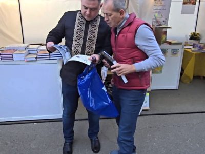 Mykola Tomenko, a public figure, leader of the Ridna Kraina movement, former MP, and ex-Deputy Prime Minister of Ukraine (2005), receives books published with UJE's support as a gift. 26 September 2025, Expocenter of Ukraine, Kyiv.
