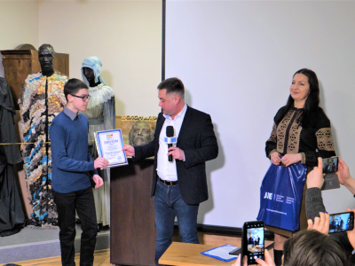 29 January 2023, Kyiv, Sholem Aleichem Museum. Vladyslav Hrynevych, Jr, UJE Regional Manager in Ukraine, presents a certificate and UJE books to a participant of the All-Ukrainian Children's Drawing Contest "Ukrainian-Jewish Encounter: We Are from Ukraine — 2022".