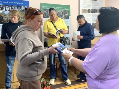 Attendees of the exhibition's opening at the Tulchyn Local History Museum receive gifts — copies of the catalog A Journey Through the Ukrainian-Jewish Encounter: From Antiquity to 1914. Tulchyn, 25 June 2025.