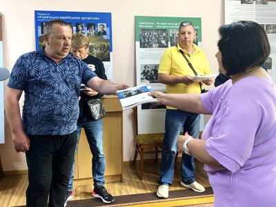 Attendees of the exhibition's opening at the Tulchyn Local History Museum receive gifts — copies of the catalog A Journey Through the Ukrainian-Jewish Encounter: From Antiquity to 1914. Tulchyn, 25 June 2025.