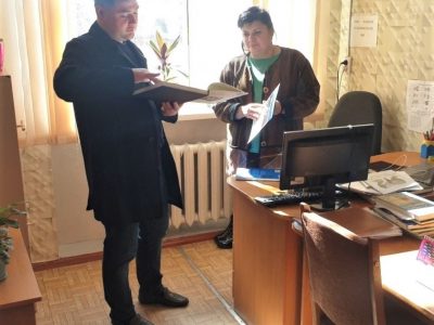 Vladyslav Hrynevych, UJE Regional Manager, Ukraine, presents books published with the support of Ukrainian Jewish Encounter to Tamila Skarbovska, director of Uman Lyceum №1. Uman, 15 March 2023. 