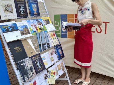 На книжковому стенді «Українсько-Єврейської Зустрічі»: відвідувачі книжкового фестивалю «VinBookFest» з цікавістю знайомляться з книжками, виданими за підтримки UJE. 14–15 вересня 2024 року, місто Вінниця.