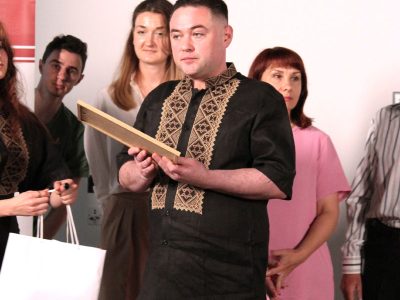 Vladyslav Hrynevych, Jr., Regional Manager of UJE's Office in Ukraine, hands an award to Petro Hrushko, the photo contest winner in the Jewish Heritage category, Kyiv, 31 May 2025.