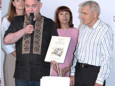 Vladyslav Hrynevych, Jr., Regional Manager of UJE's Office in Ukraine, hands an award to Petro Hrushko, the photo contest winner in the Jewish Heritage category, Kyiv, 31 May 2025.